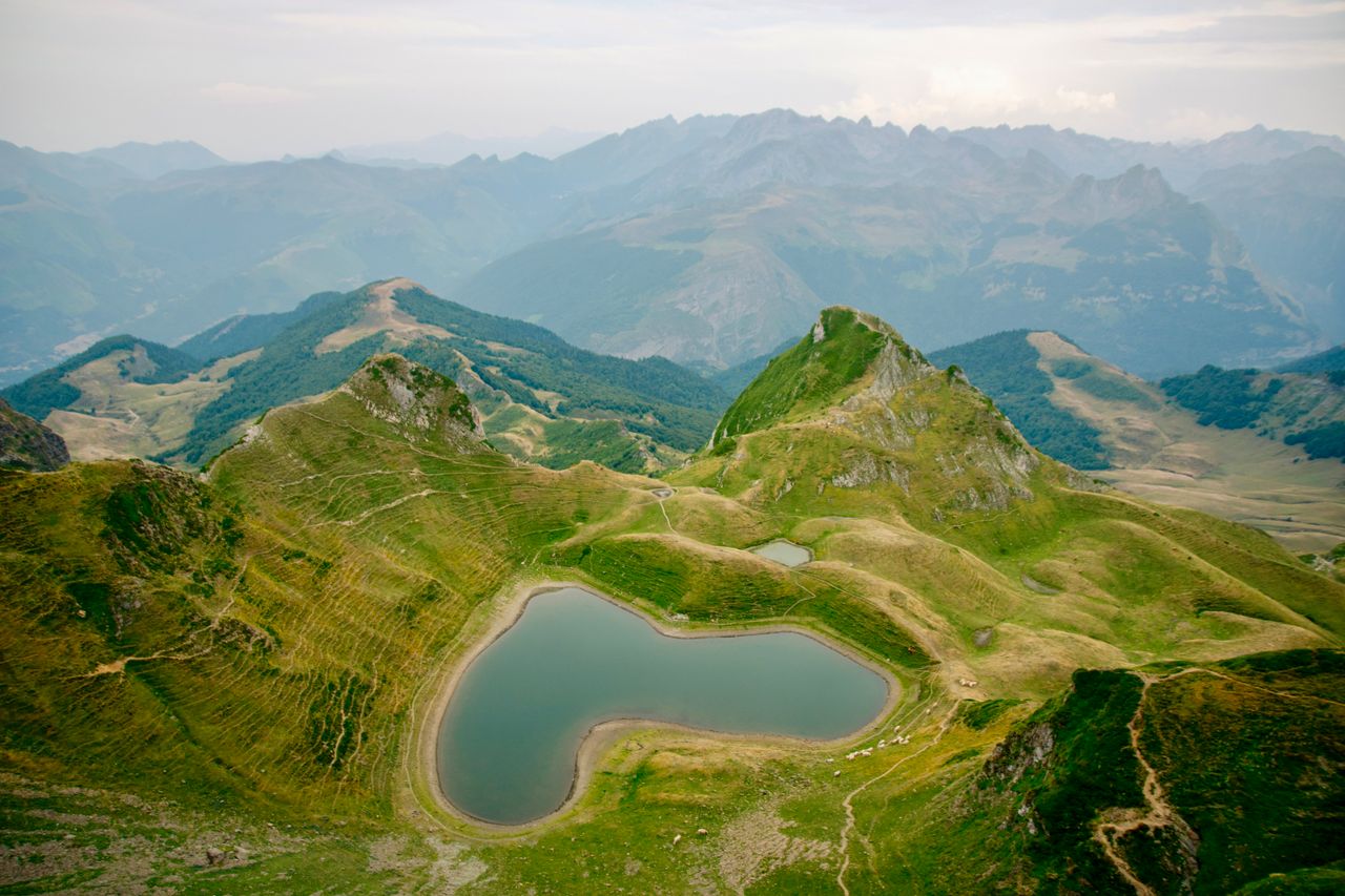 Services Aerial view of a heart-shaped lake and mountains in Accous, Nouvelle-Aquitaine, France.